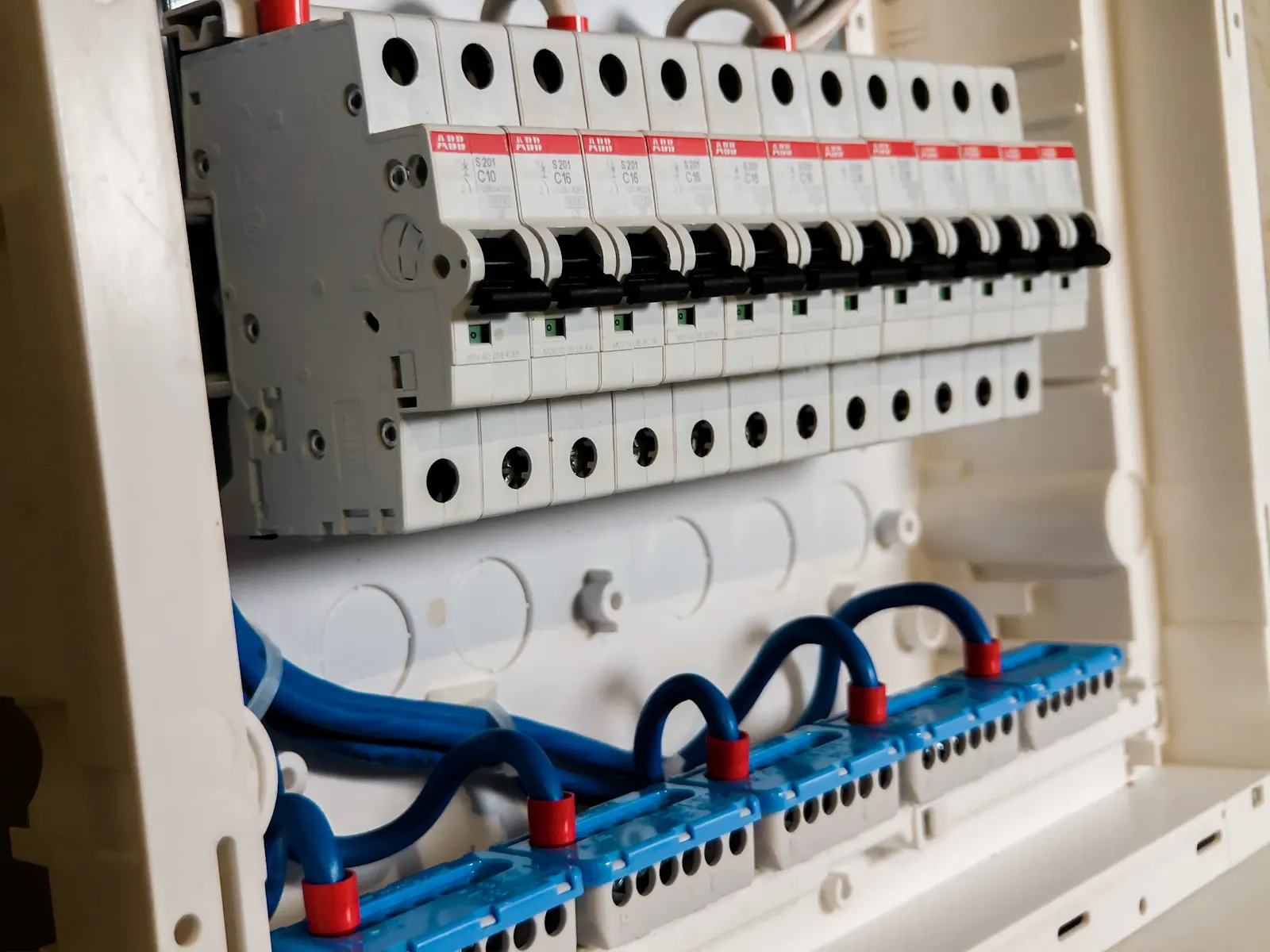 Row of white miniature circuit breakers in a distribution board