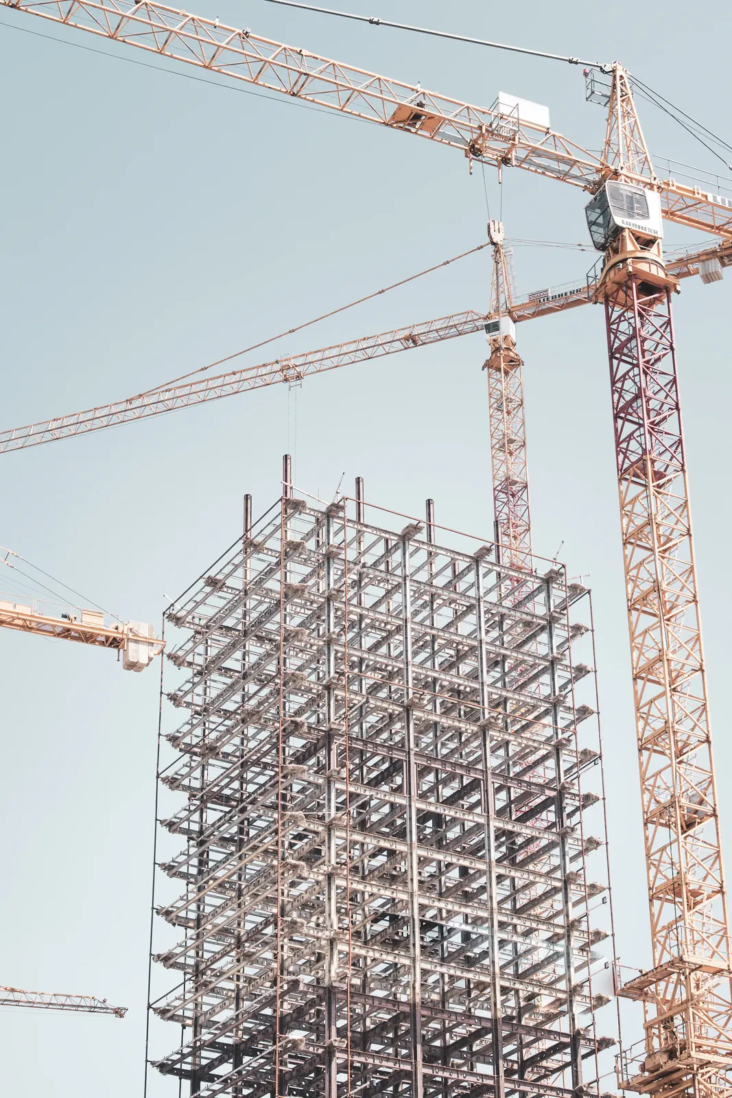 Building frame under construction beside a tower crane